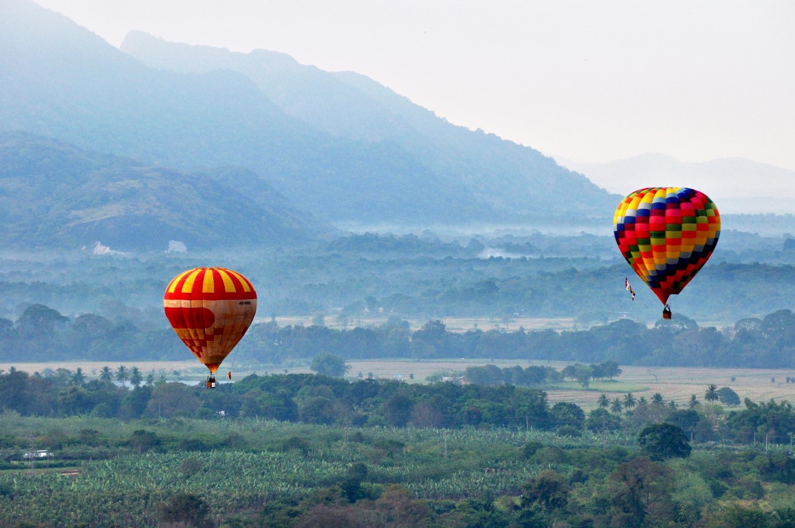 Hot air balloon drifting peacefully over lush countryside