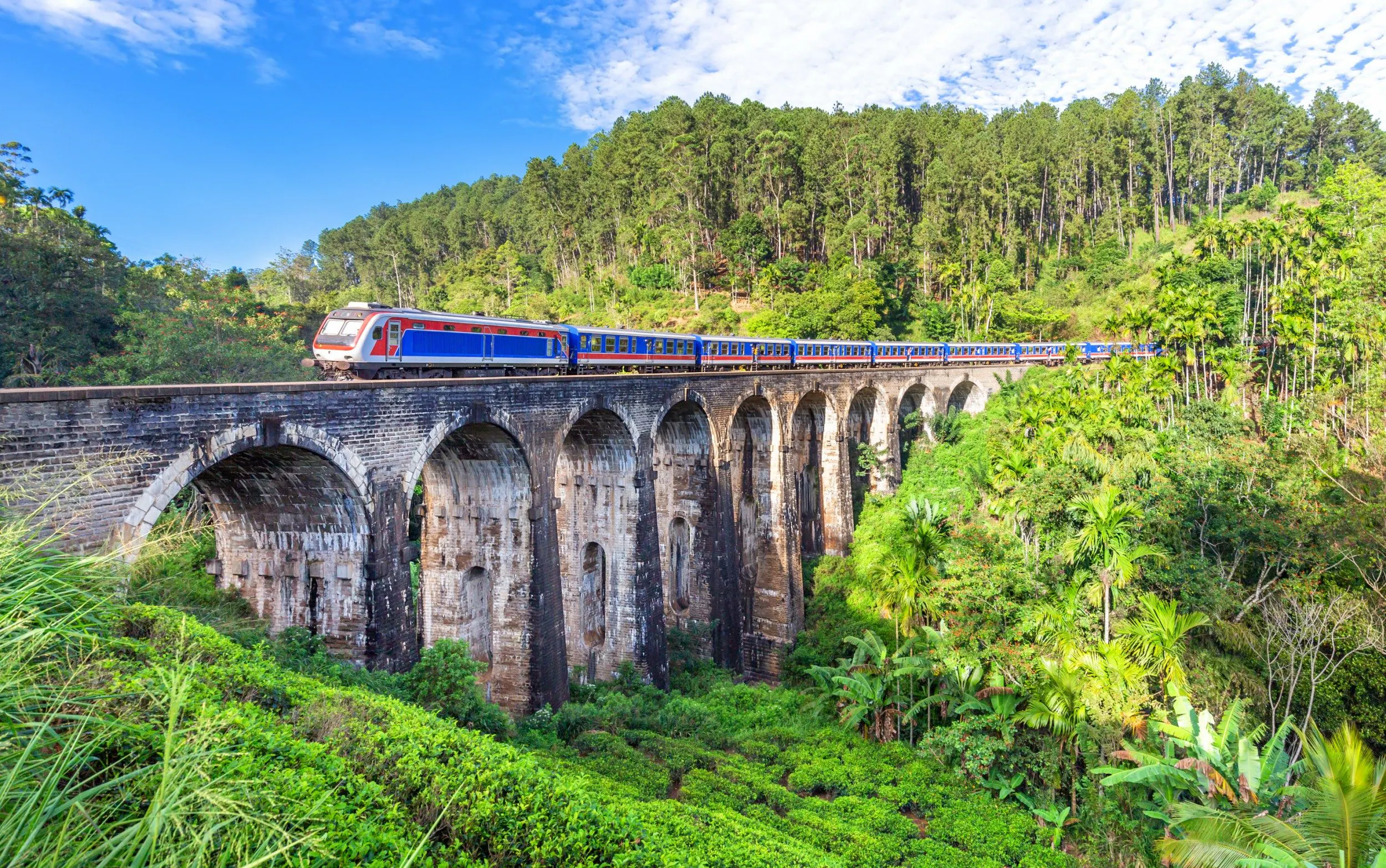 Scenic blue train crossing the Nine Arch Bridge in Ella