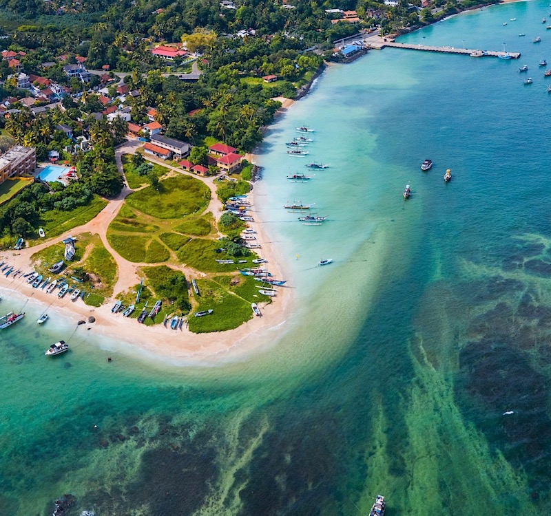 Sandy coastal bay with gentle surf in Weligama
